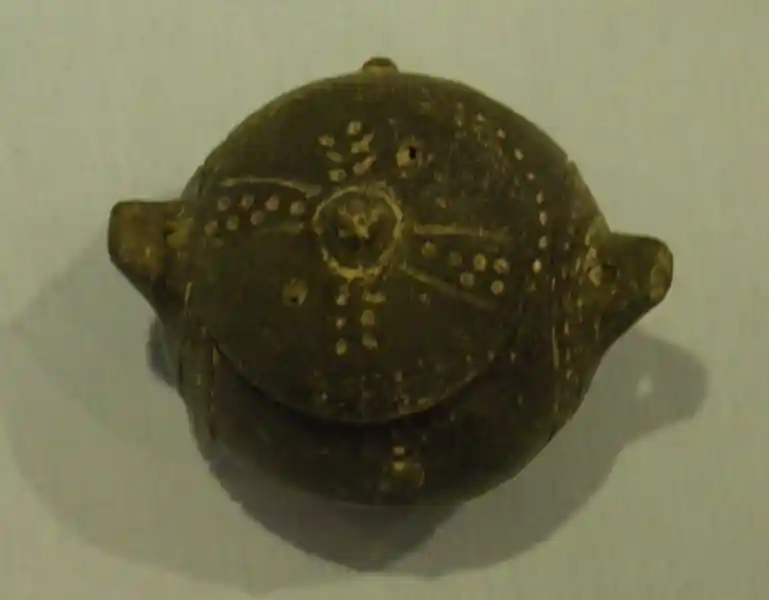 Pre-Christian textured cross on a composite vessel during Bronze Age. The cross is composed of dots and is on the lid of the vessel.